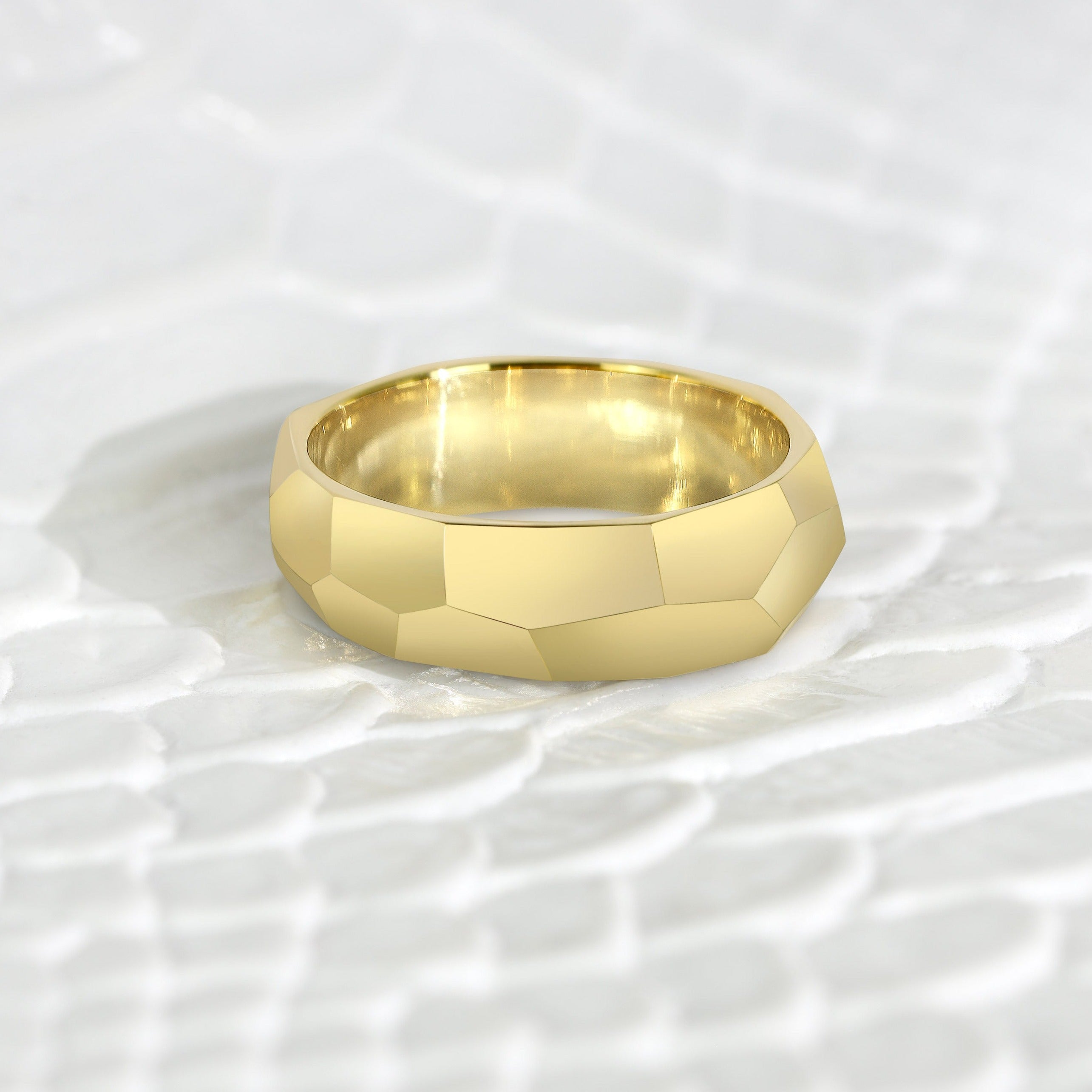 faceted gold ring on textured background