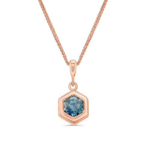 Rose gold necklace with a hexagon cut montana sapphire pendant on a white background