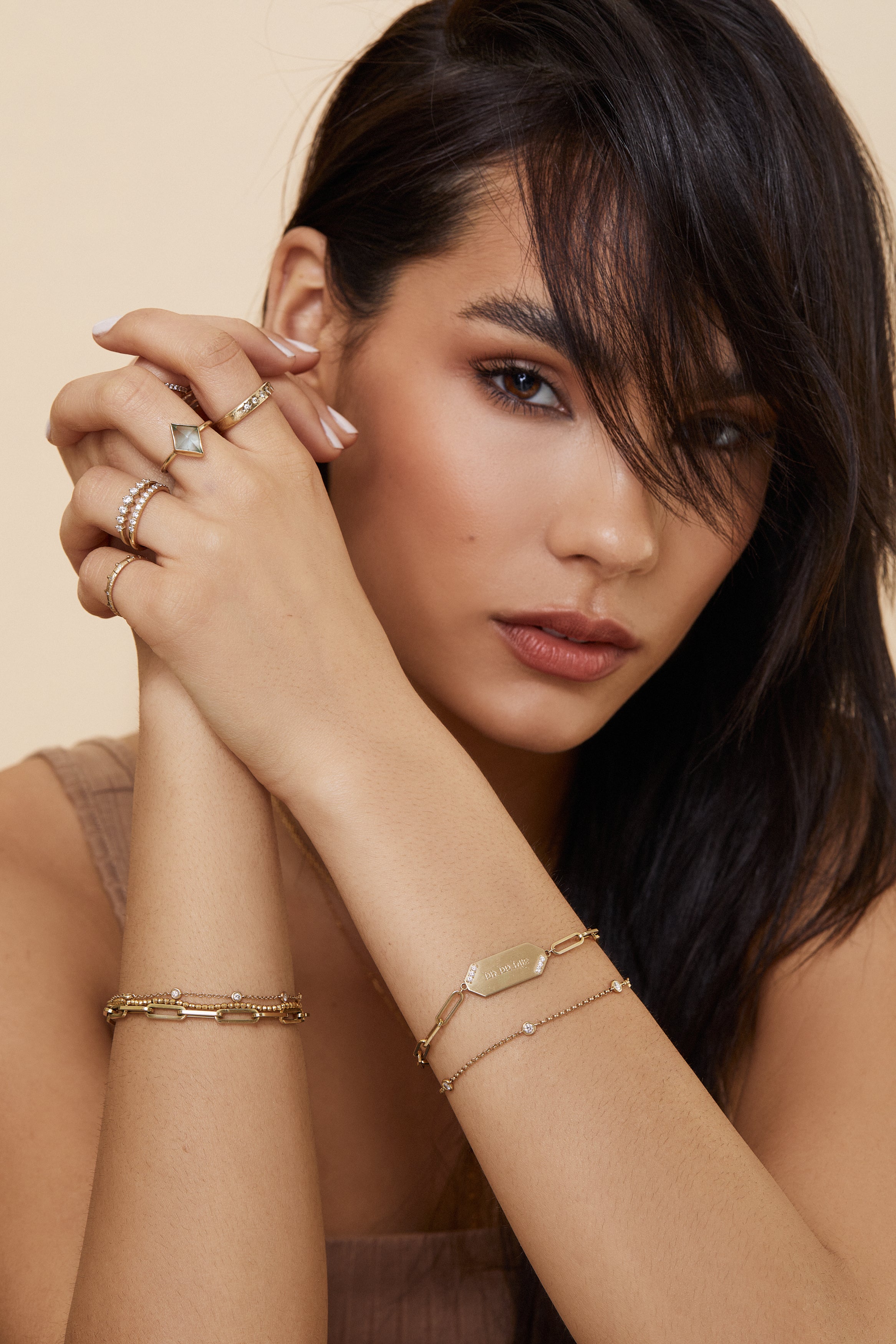 Elegant woman wearing unique 14ky gold rings and bracelets. Shop with Carter Eve Jewelry for a touch of luxury.